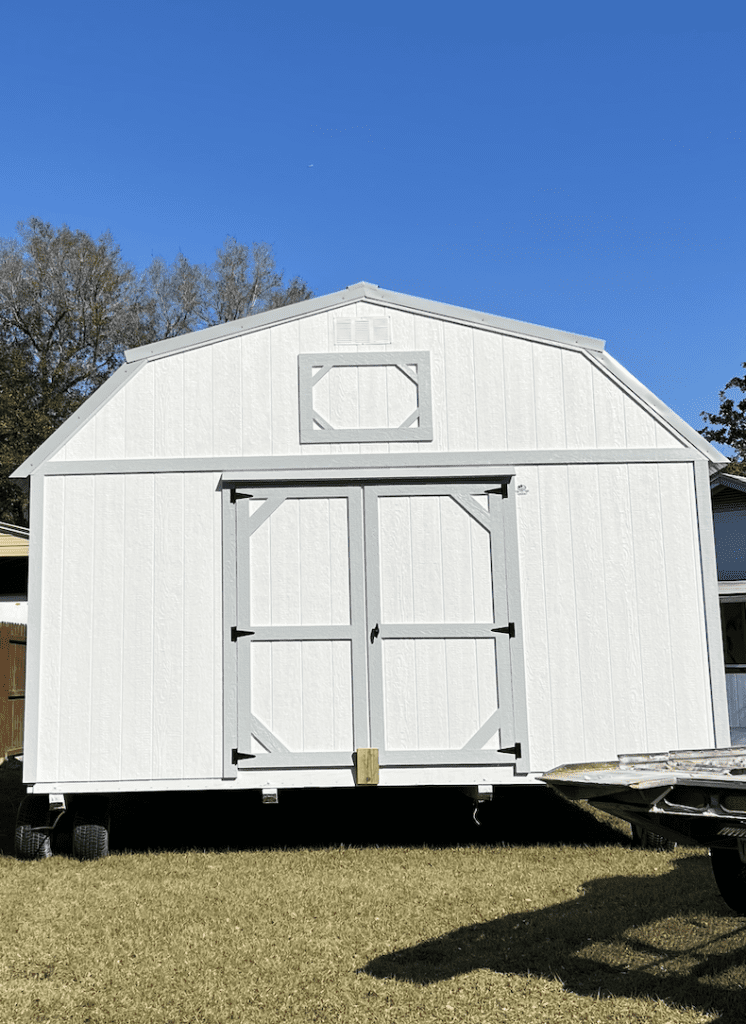 The front of a gray she shed with double barn doors
